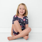 Seated girl in Moonlit Galaxy girls bamboo pajamas
