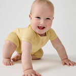 Crawling baby wearing Sunglow yellow bamboo shorty zippy pajamas