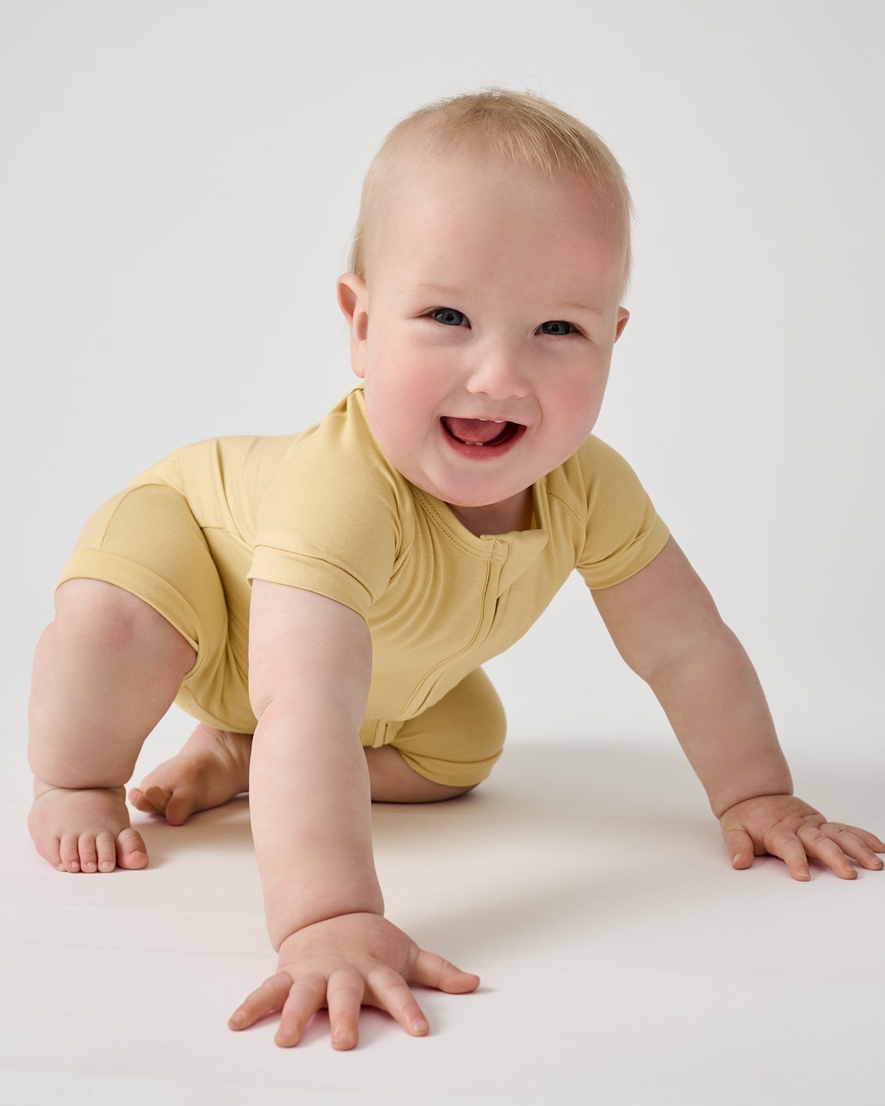 Crawling baby wearing Sunglow yellow bamboo shorty zippy pajamas