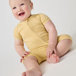 Smiling baby wearing the Sunglow yellow bamboo shorty zippy pajamas